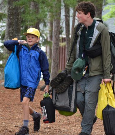 counselor walking with camper on trail