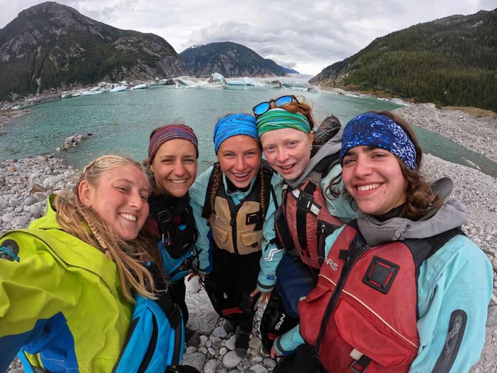 campers posing for pic in front of river and mountains